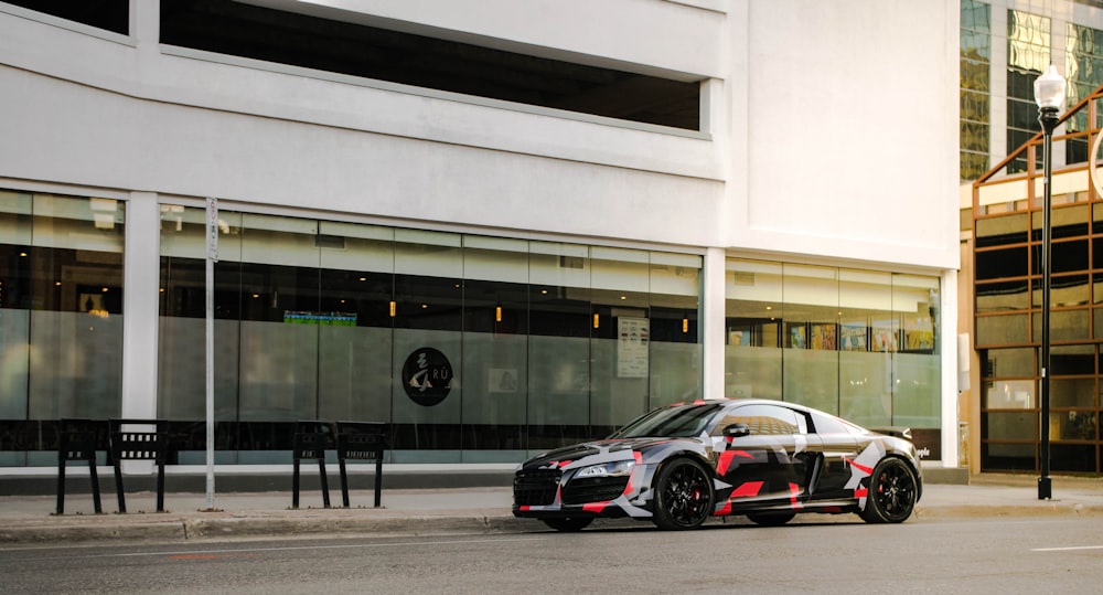 parked black and red coupe car near building