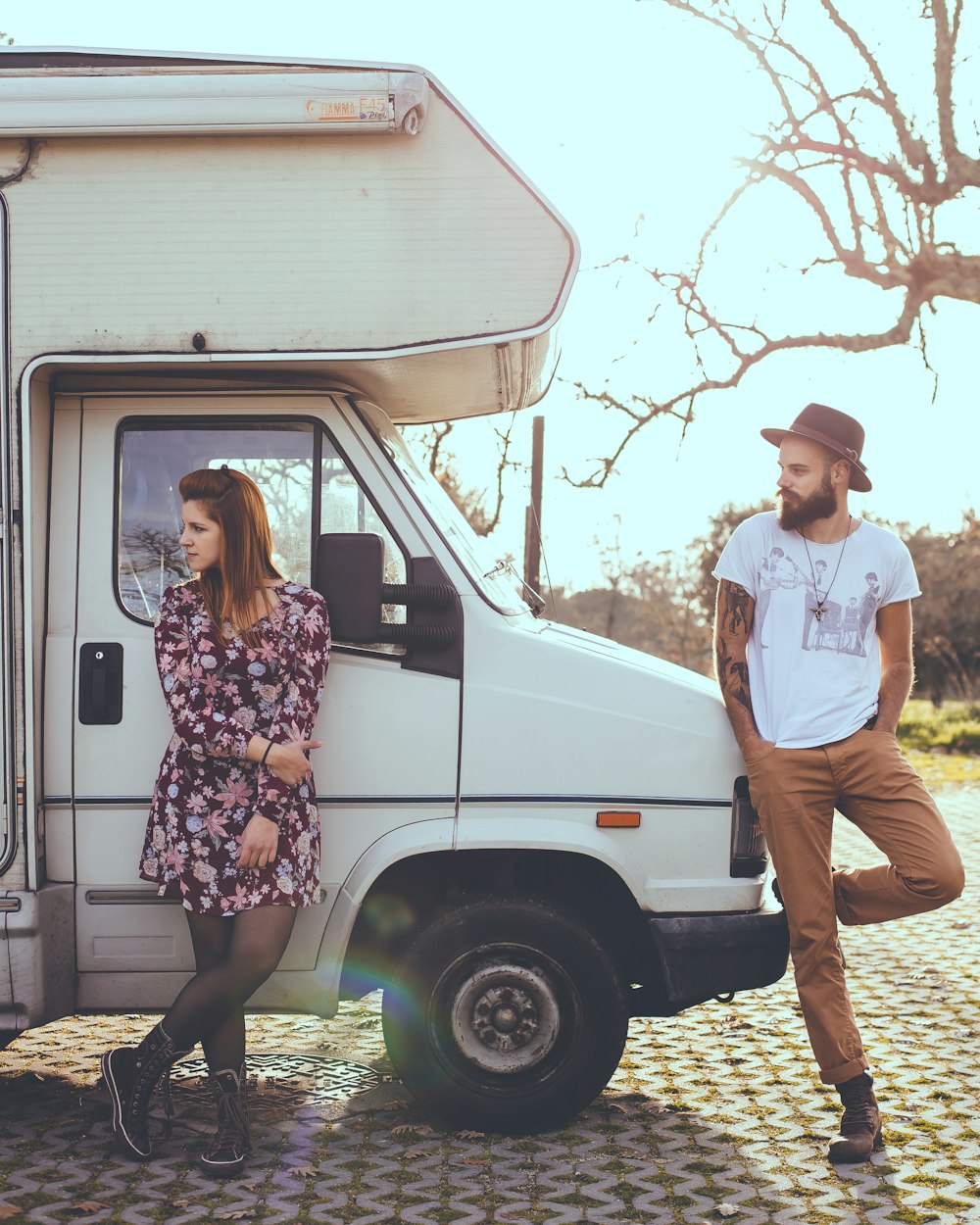 man and woman leaning on white RV trailer