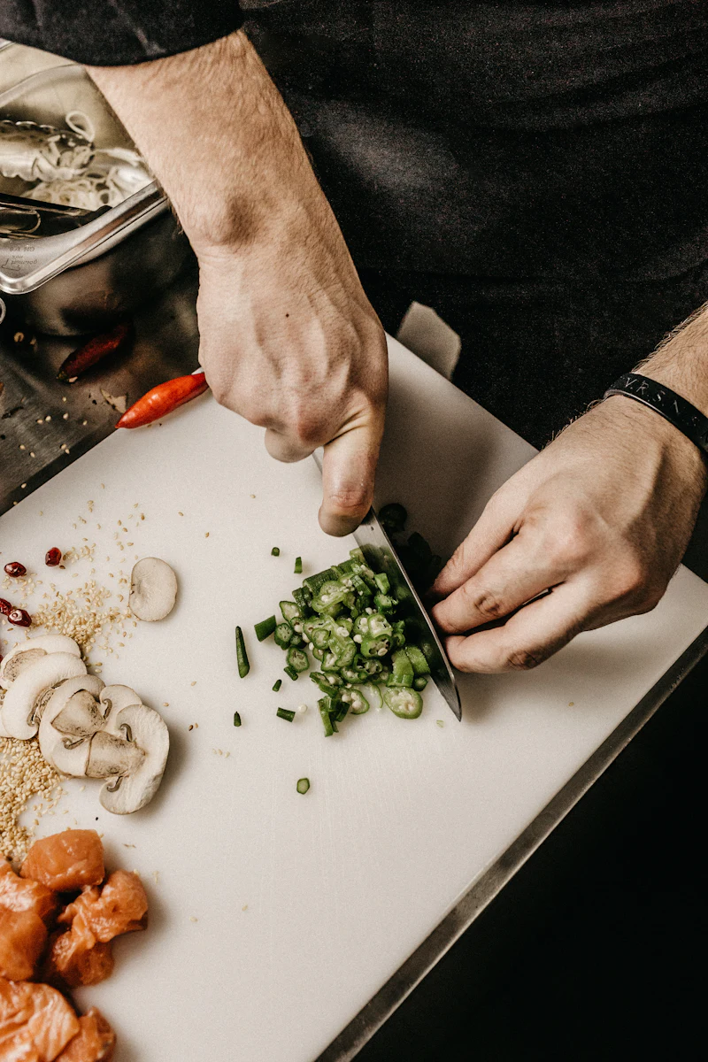 Chef cortando verduras frescas sobre una tabla en una cocina profesional