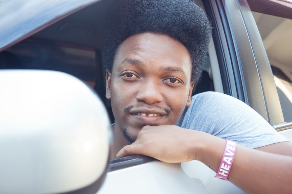 man sitting on front of white vehicle