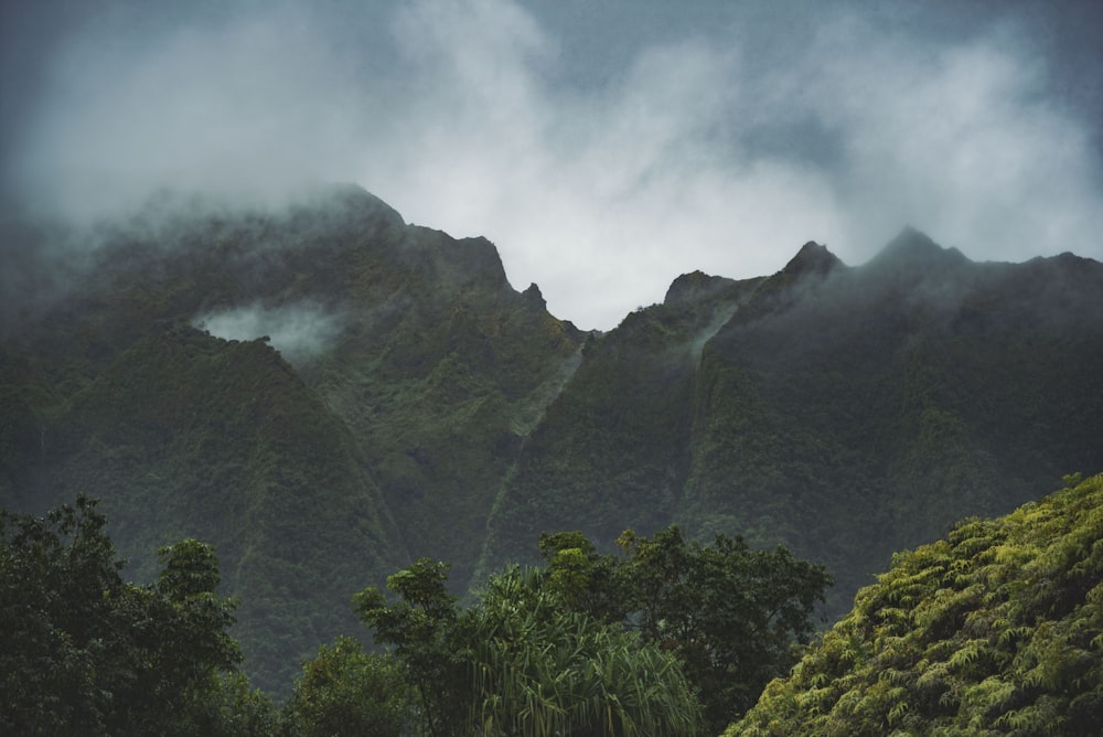 green mountain across clouds photo