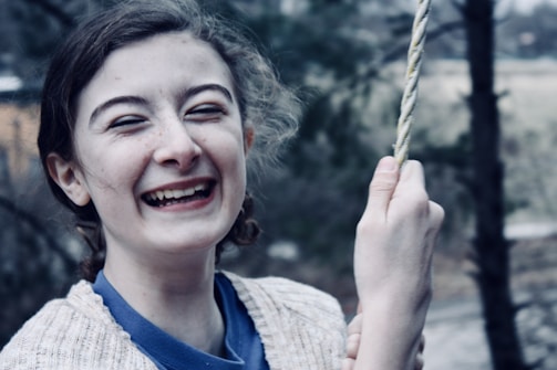 A joyful young student practicing aerial silks with a big smile.