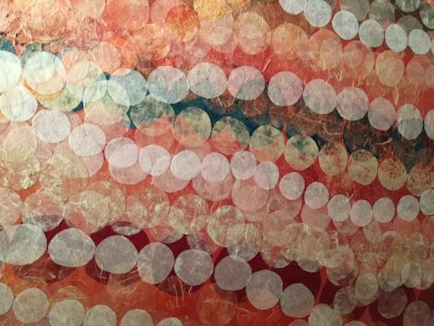Abstract string art installation with overlapping circles in warm tones.