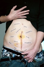 person wearing black shirt showing tummy with text
