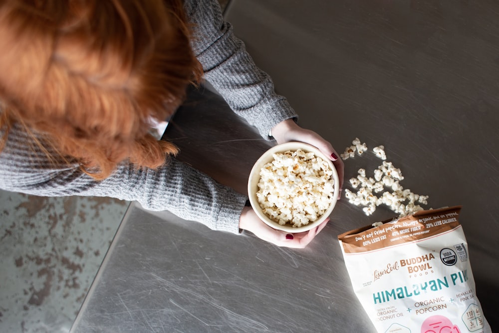woman holding bowl of popcorn