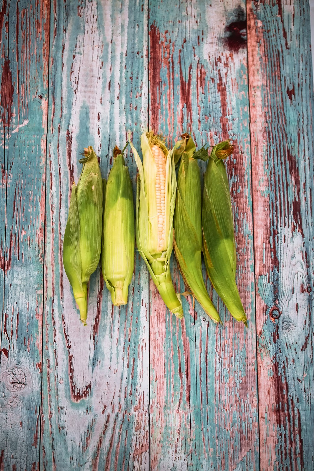 green corns on wooden surface