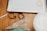 On a wooden surface, there are several baking tools including cookie cutters, a piping bag, and a metal baking tray. The cookie cutters are shaped like a teapot and a hexagon, and a partially cut piece of dough is also visible.
