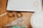 On a wooden surface, there are several baking tools including cookie cutters, a piping bag, and a metal baking tray. The cookie cutters are shaped like a teapot and a hexagon, and a partially cut piece of dough is also visible.
