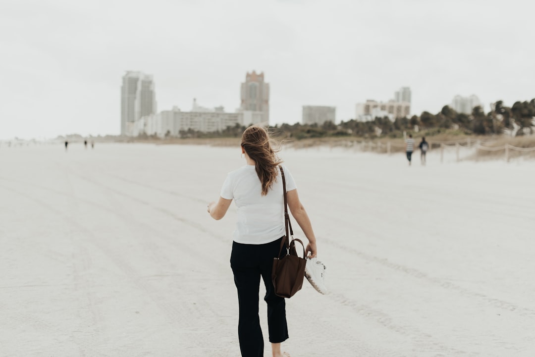 woman walking on seashore during day time
