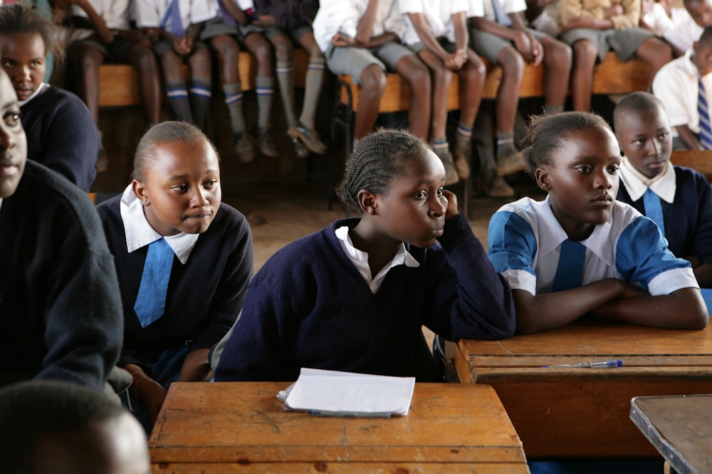 students sitting on brown wooden table