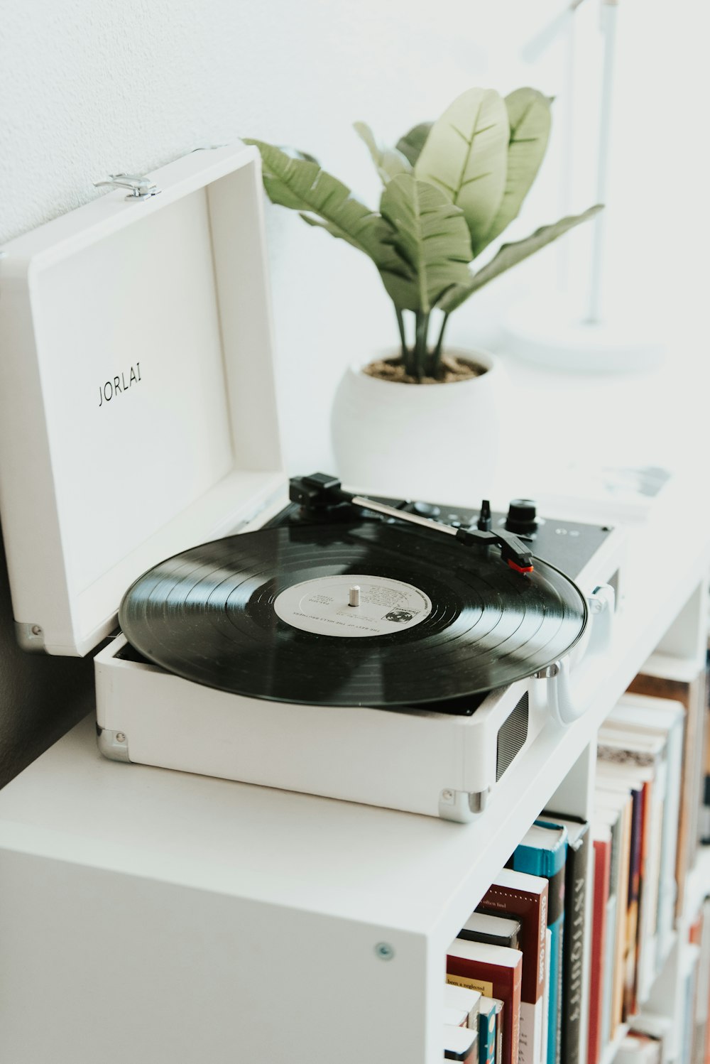 white vinyl player beside plants