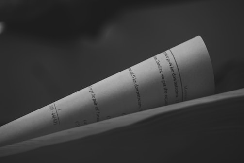 A close-up image of a sheet of paper with printed text. The paper is slightly curved, and the text includes numeric values and English words. The background is blurred, creating a focus on the paper and its contents.
