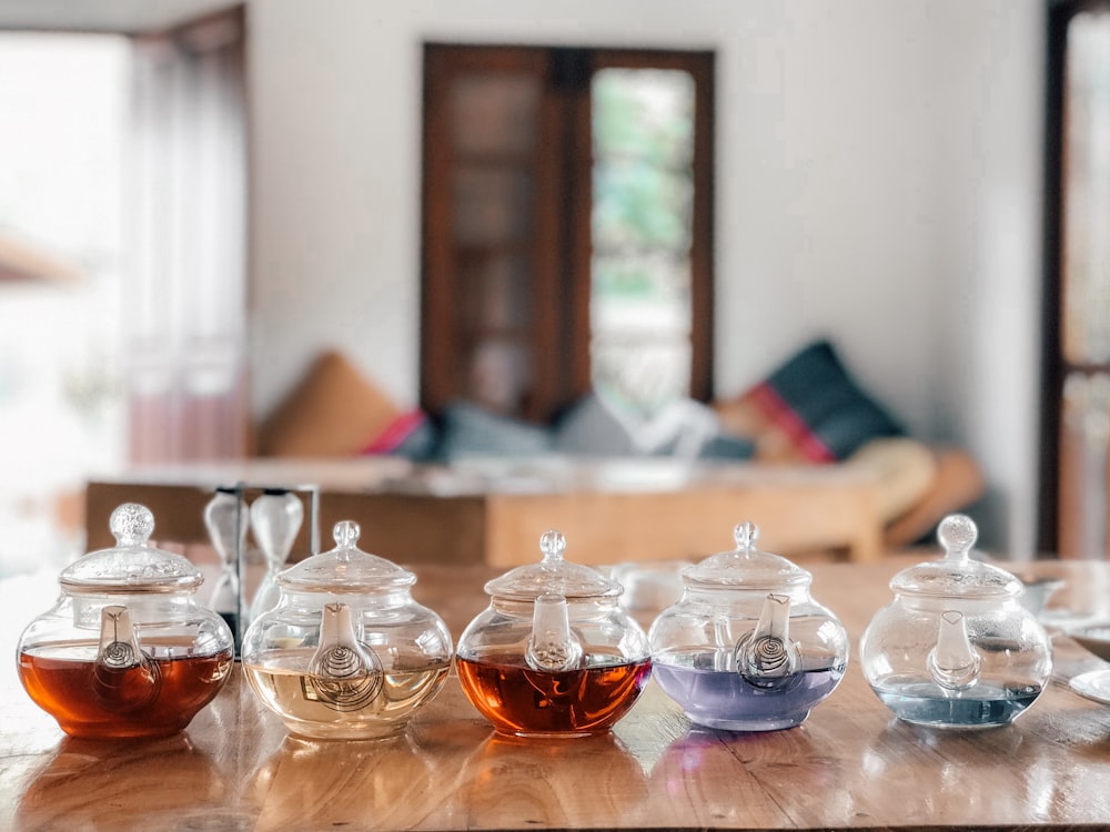 five clear glass teapots