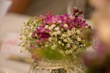 Close-up of delicate white lilies and baby's breath in a rustic vase
