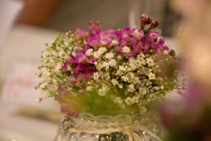 Close-up of delicate white lilies and baby's breath in a rustic vase
