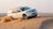 A shiny white SUV cruising along a desert road with golden dunes in the background.