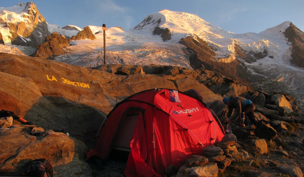 red and black dome tent on mountain peak