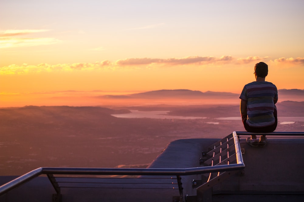 man sitting on railing