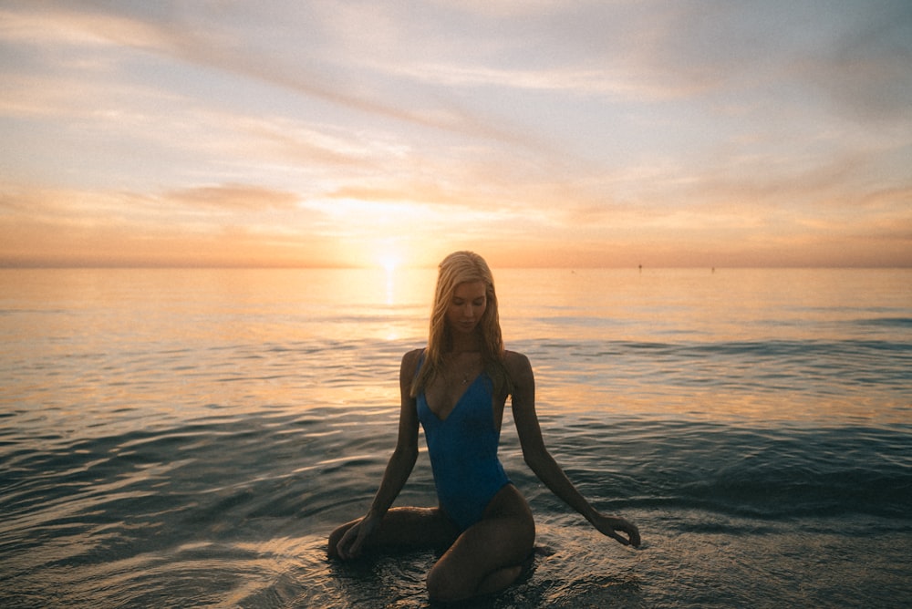 woman in blue monokini on body of water