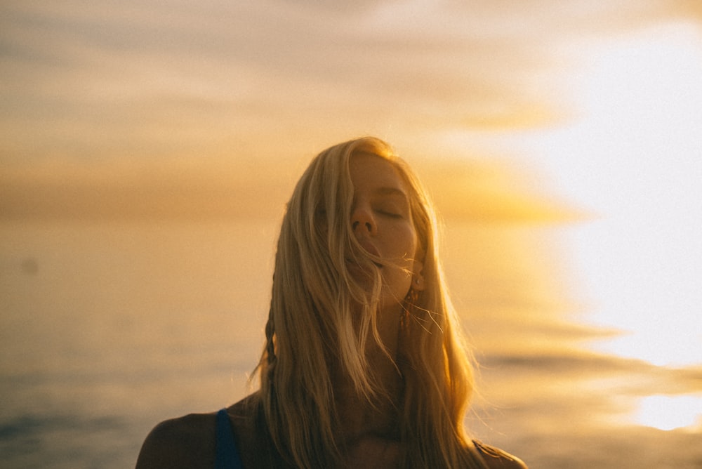 woman closing her eyes during golden hour
