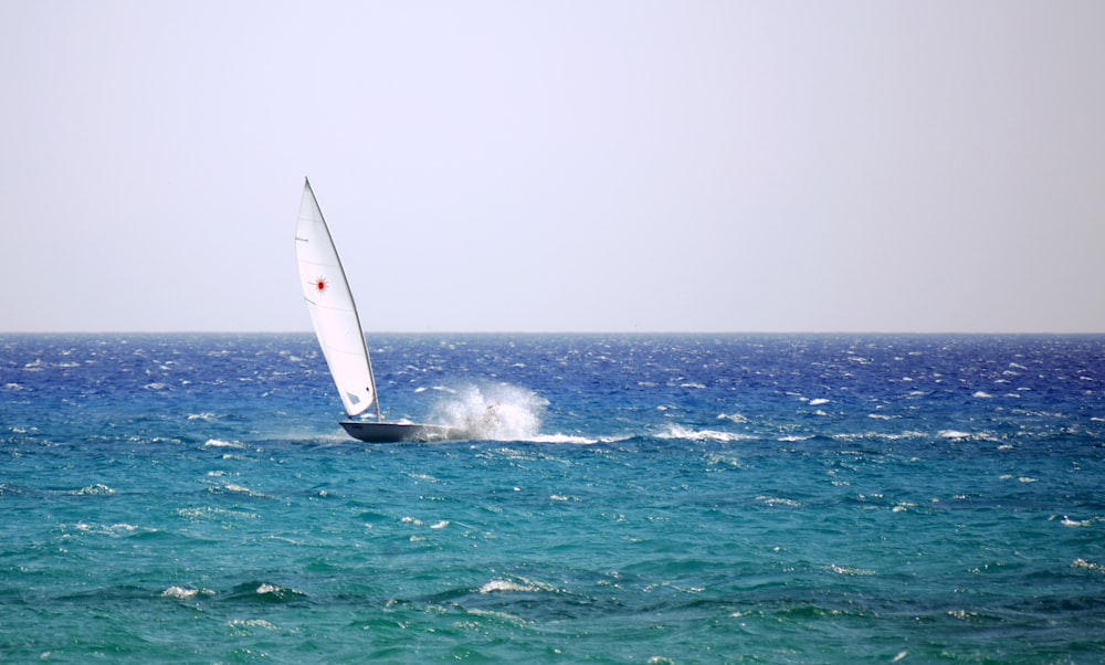 yacht with white sail speeding at ocean