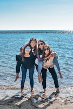 A group of friends enjoying a beach day, laughing and cheering each other on.