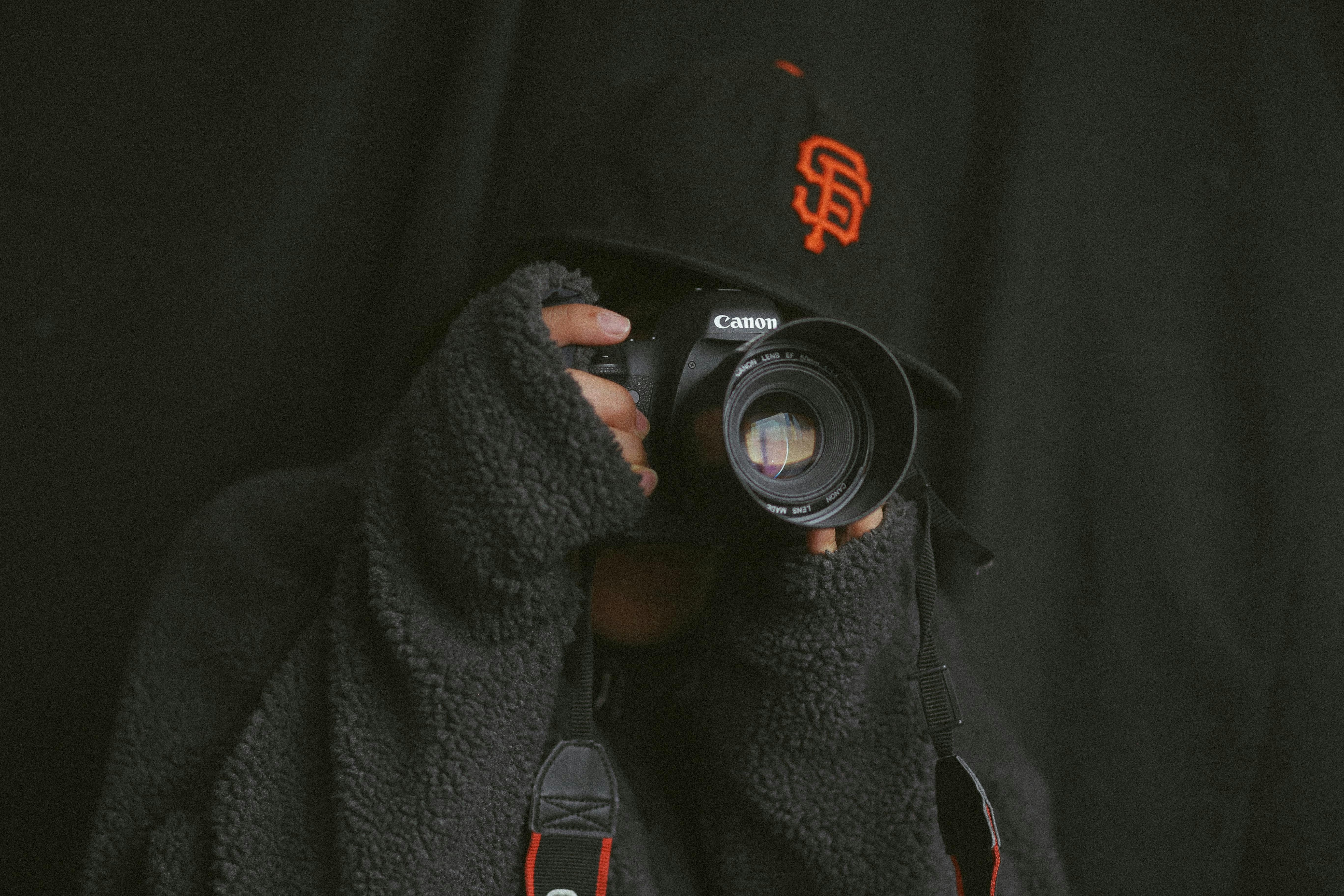 persona che usa una fotocamera Canon nera