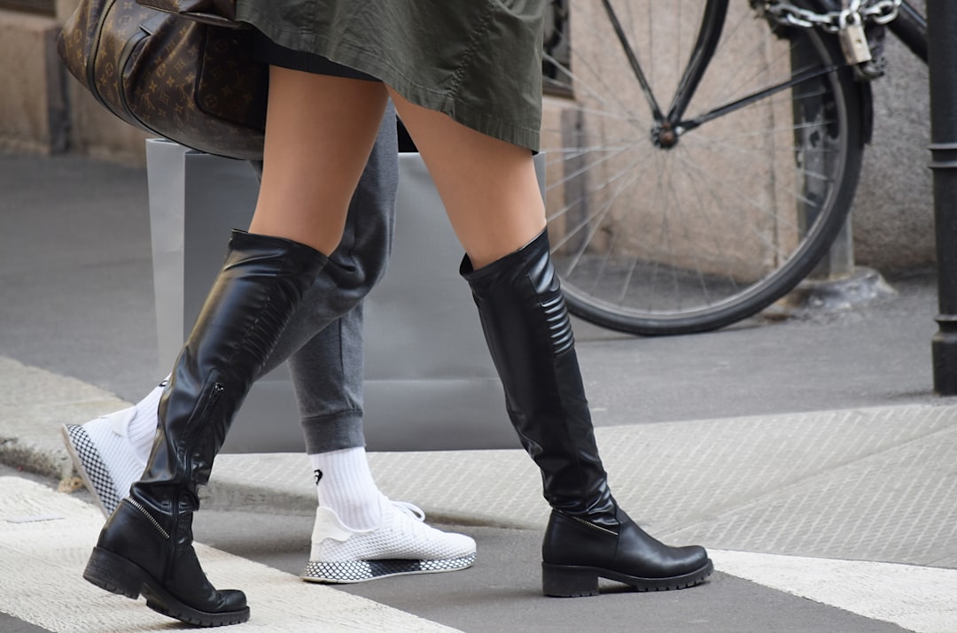 person wearing black leather boots