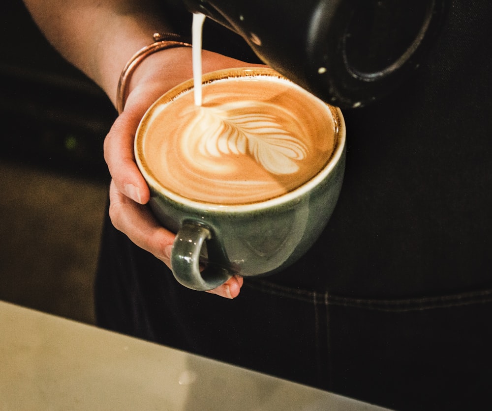 person pouring coffee on cup