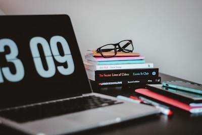 silver MacBook Pro near books