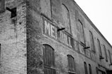 Before shot of a weathered brick warehouse in Birmingham with faded signage.
