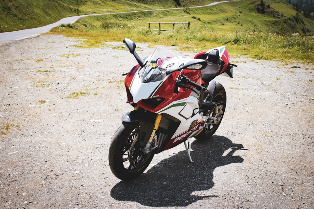 red and white sports bike near grass field