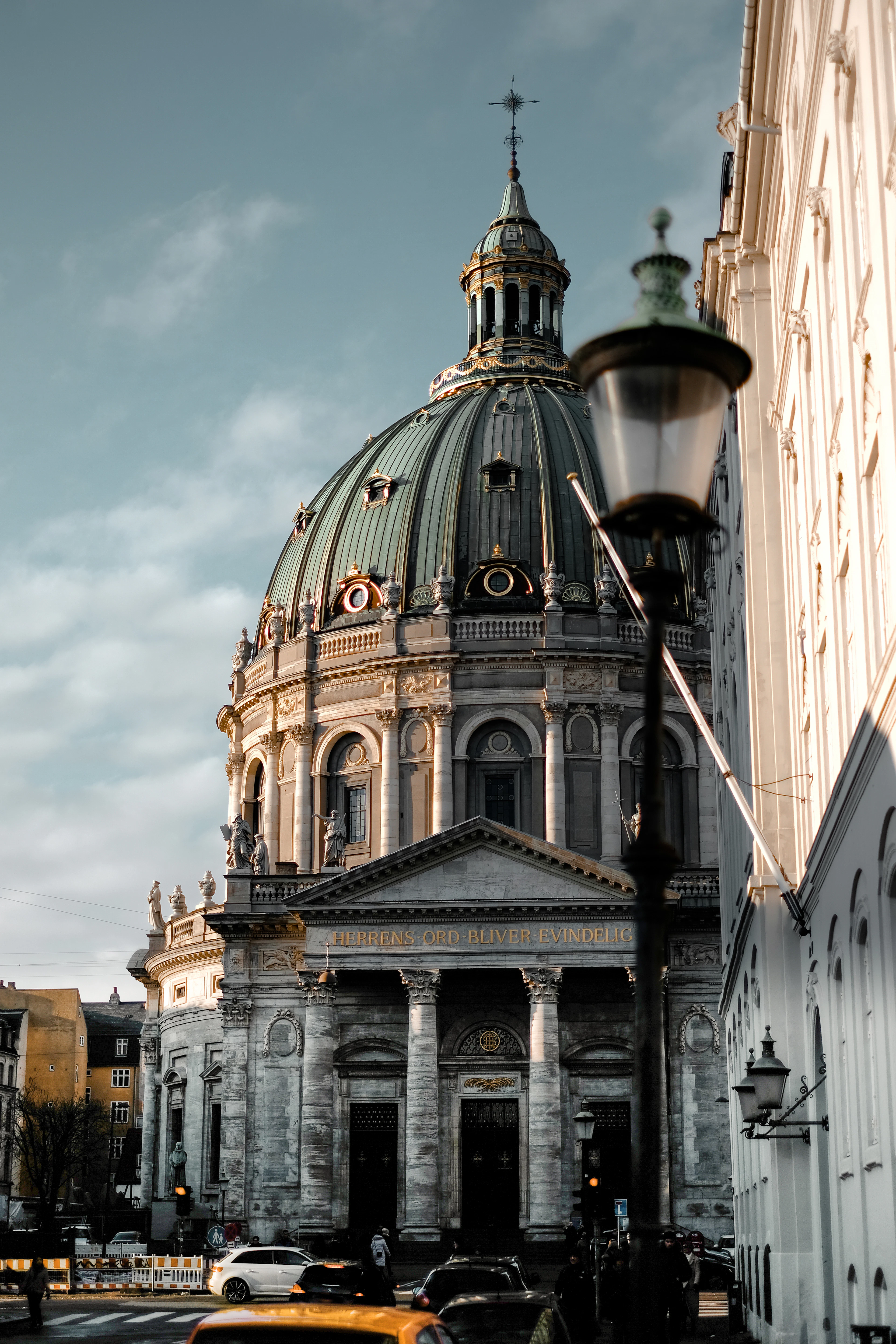 The green copper dome and columned portico of Frederik's Church, the Marble Church, on a Copenhagen street corner