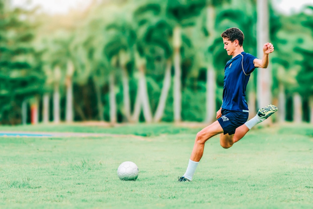 hombre tratando de patear la pelota de fútbol