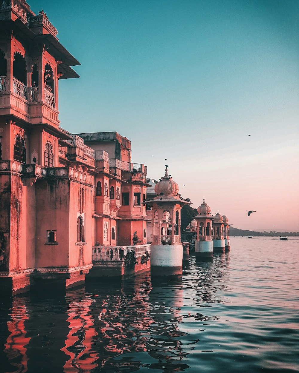 beige painted building near body of water during daytome