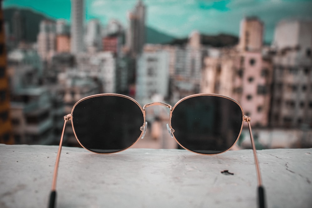 gold-colored framed sunglasses on white surface