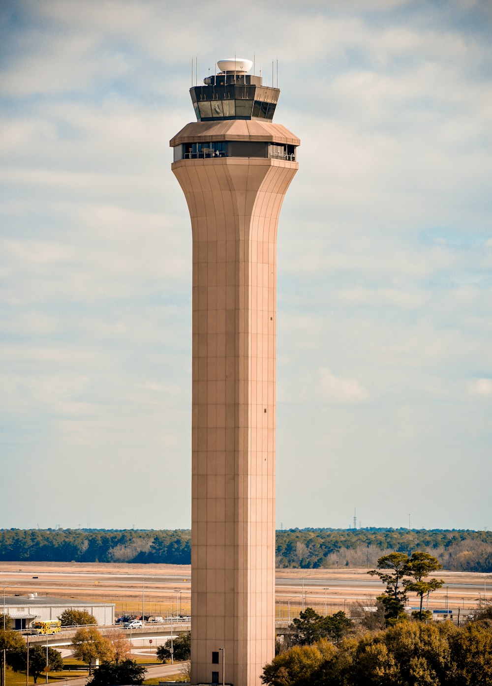 昼間の灰色の空の下に茶色の管制塔
