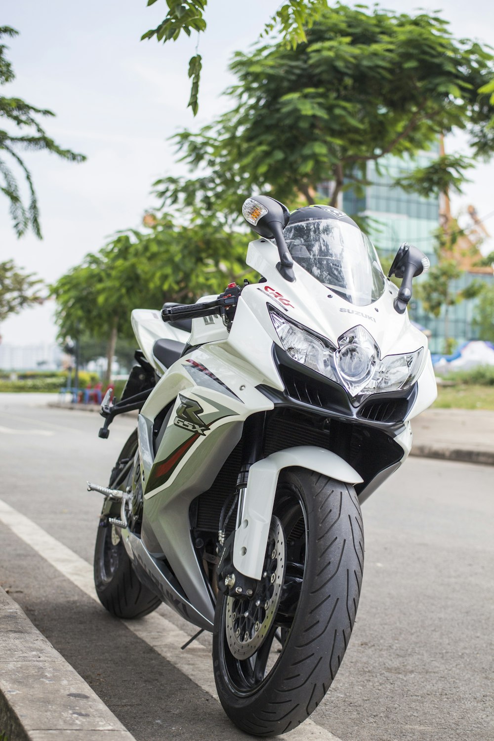 white sports bike parking near road