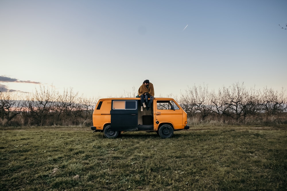 person sitting on top of orange van