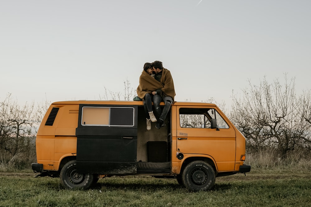 man and woman on yellow utility van