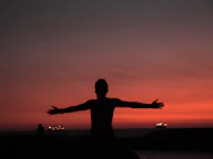 silhouette of man spreading both arms