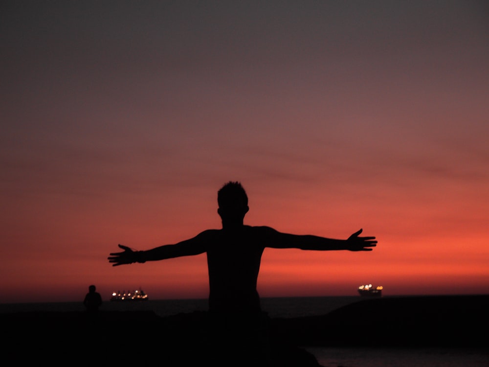 silhouette of man spreading both arms