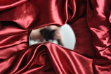 round mirror on red textile