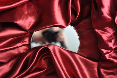 round mirror on red textile