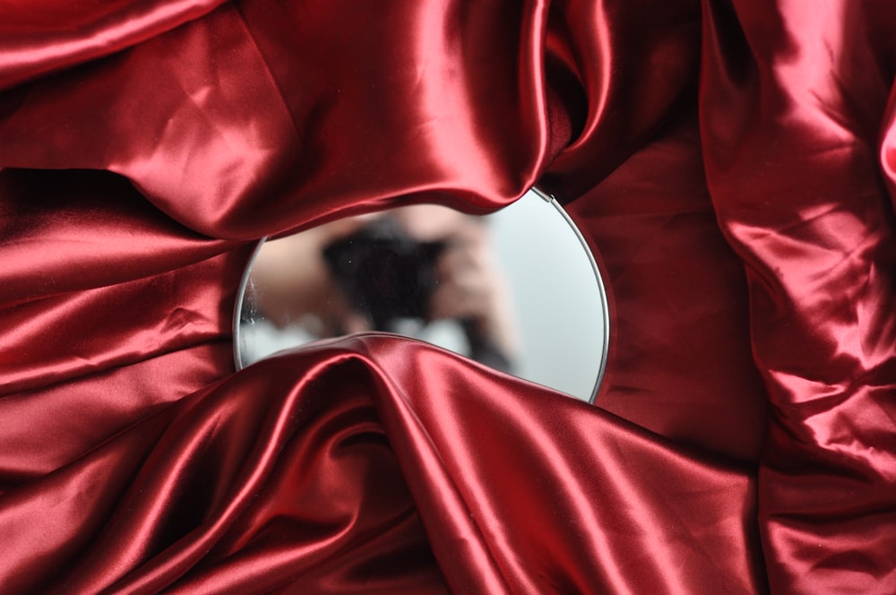 round mirror on red textile