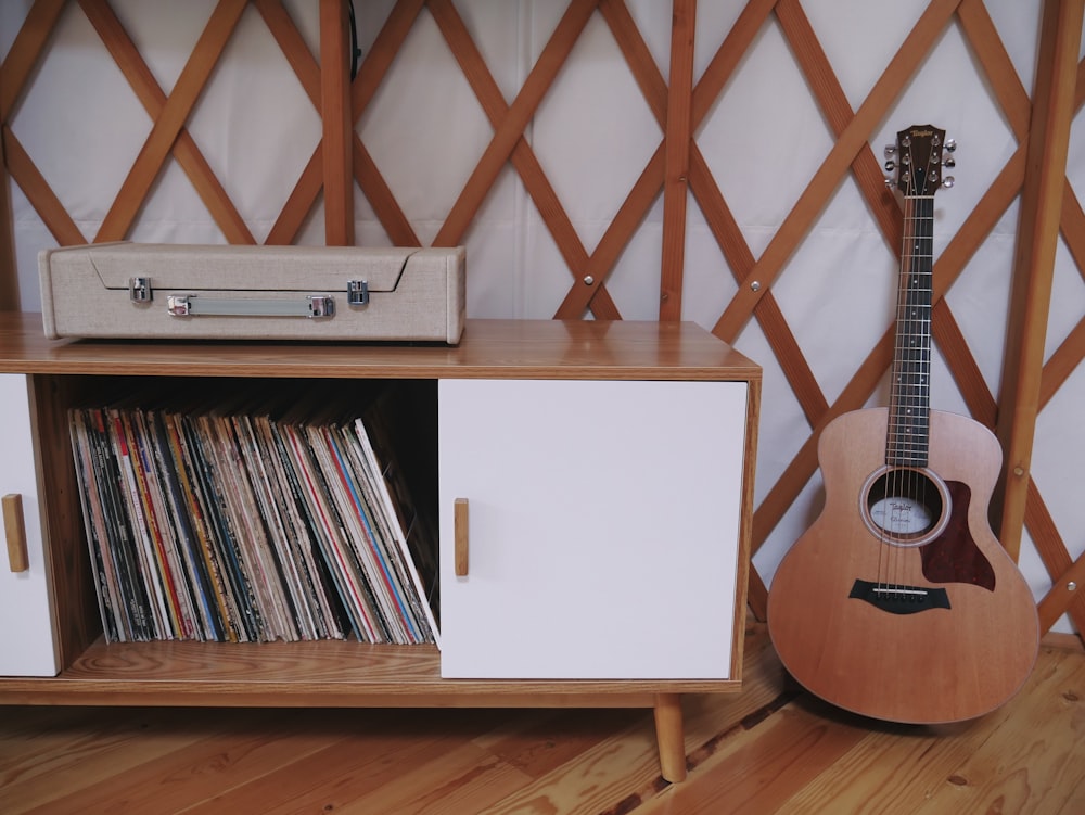 white sideboard beside guitar