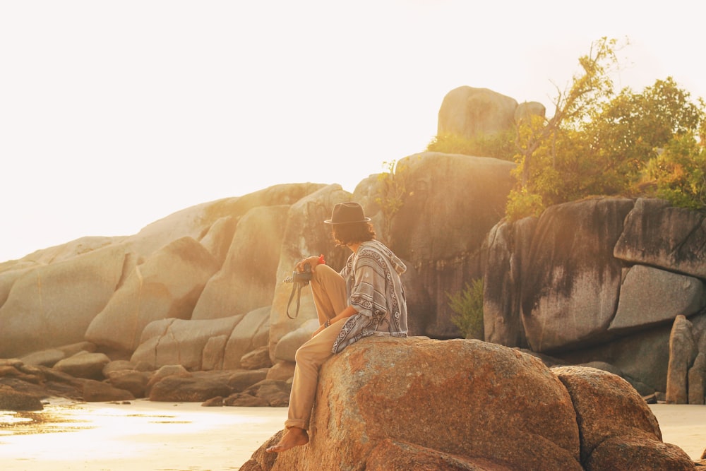 man sitting on rock