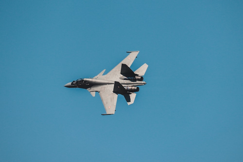 avion de chasse gris sous un ciel bleu