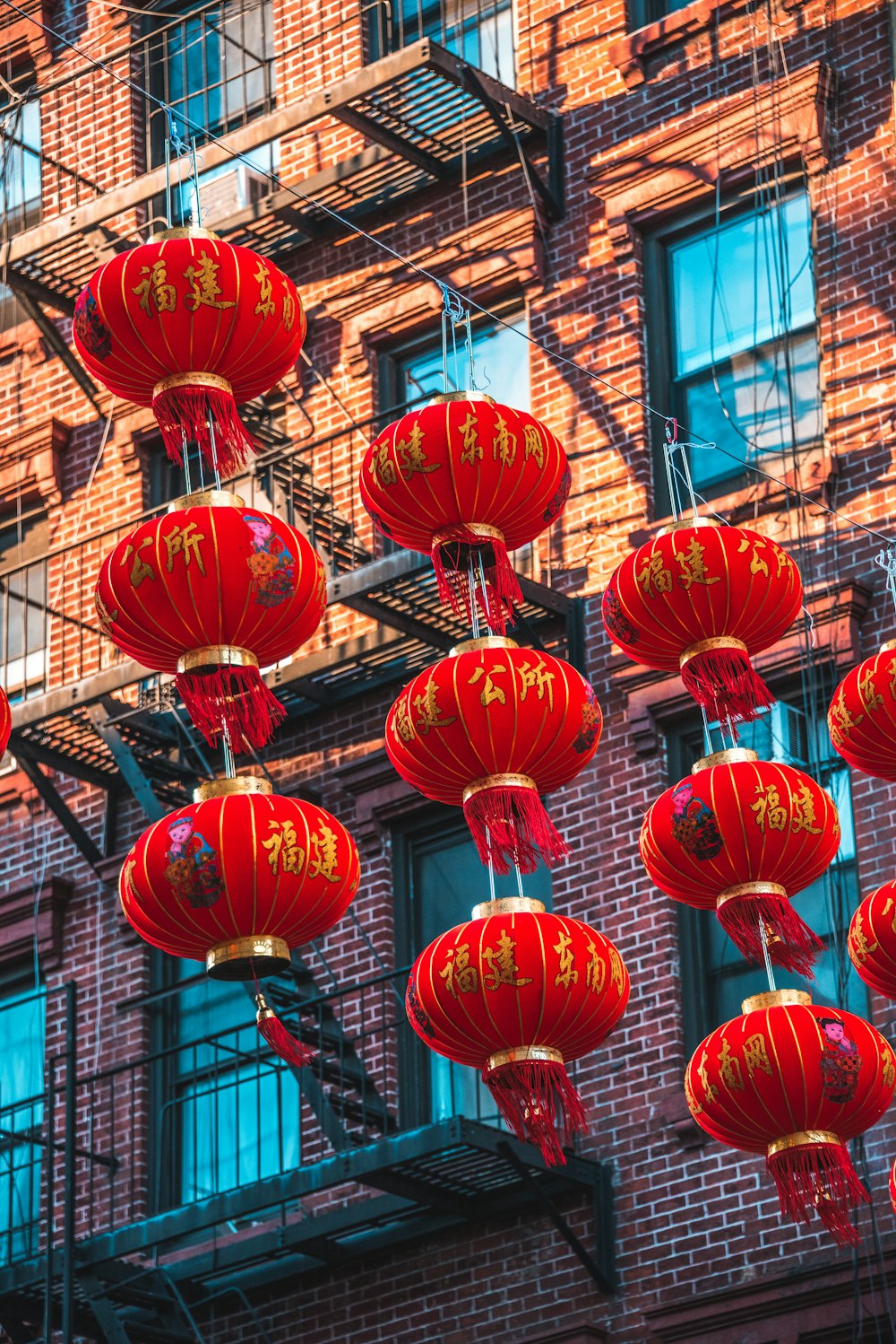 orange Chinese lanterns hanging beside brown building