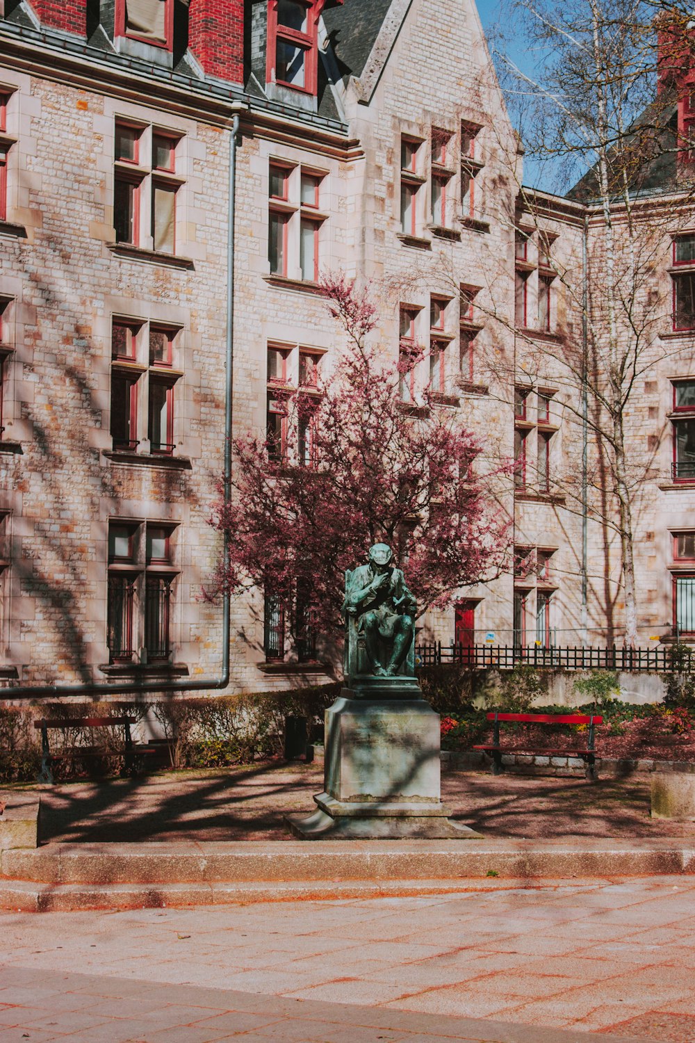 gray statue near tree during daytime